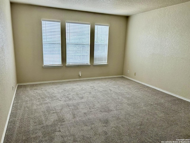 unfurnished room featuring carpet flooring and a textured ceiling