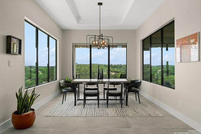 sunroom / solarium with a chandelier and a raised ceiling