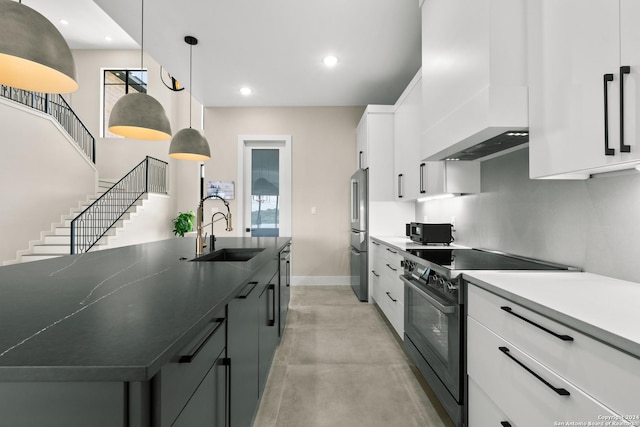 kitchen featuring custom exhaust hood, high end appliances, sink, white cabinets, and hanging light fixtures