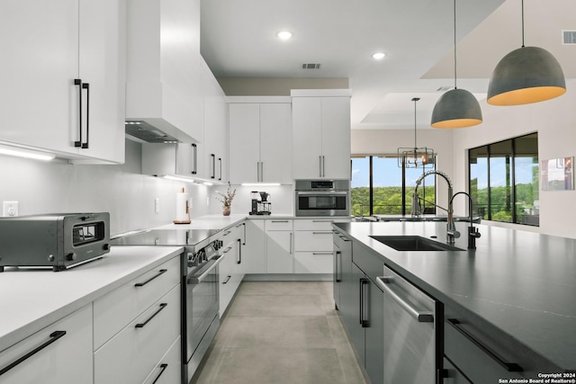 kitchen featuring white cabinets, pendant lighting, and appliances with stainless steel finishes