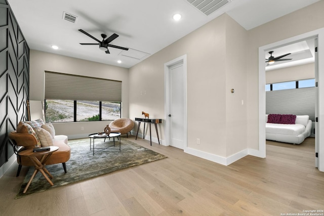 sitting room with light hardwood / wood-style floors and ceiling fan