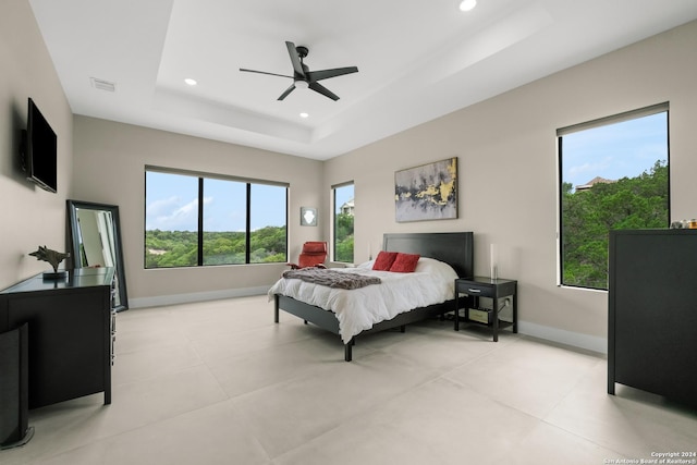 bedroom with ceiling fan and a tray ceiling