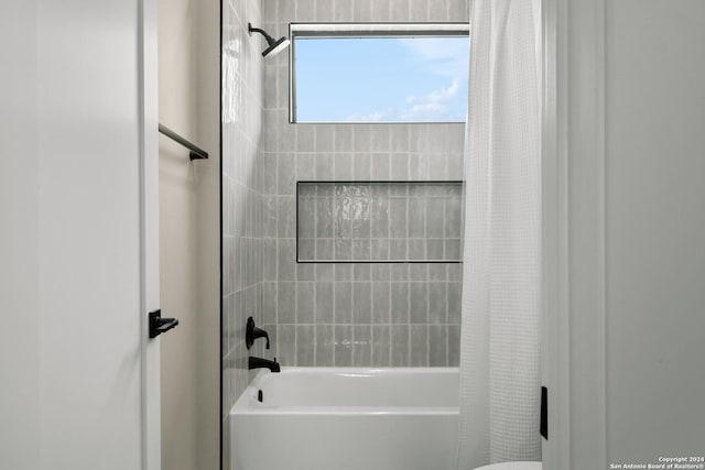 bathroom with toilet and shower / bath combo with shower curtain