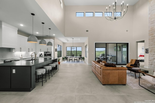 living room featuring a chandelier, a high ceiling, and sink