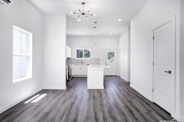 kitchen featuring pendant lighting, white cabinets, a kitchen island, dark hardwood / wood-style flooring, and a chandelier