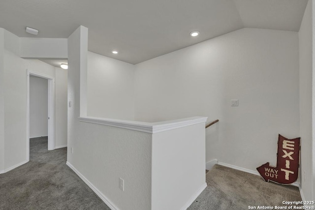 hallway featuring carpet floors and lofted ceiling