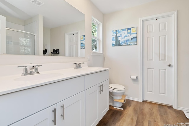 bathroom featuring vanity, an enclosed shower, wood-type flooring, and toilet