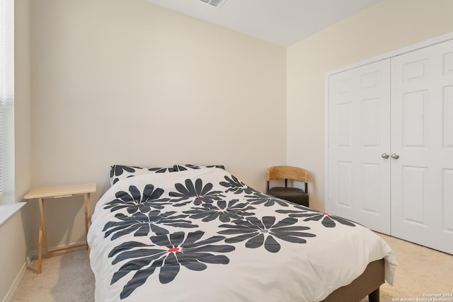 bedroom featuring light colored carpet and a closet