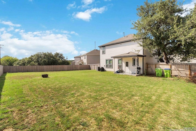 back of property with a lawn and an outdoor fire pit