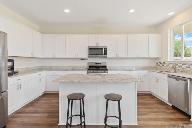 kitchen featuring white cabinetry, stainless steel appliances, a center island, and sink