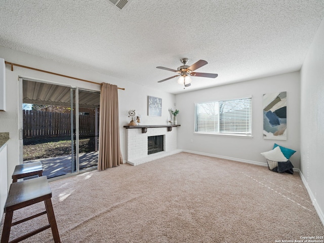 unfurnished living room with a fireplace, a textured ceiling, carpet flooring, and ceiling fan