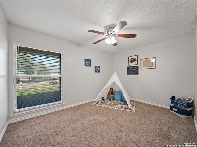 game room with ceiling fan, carpet floors, and a textured ceiling