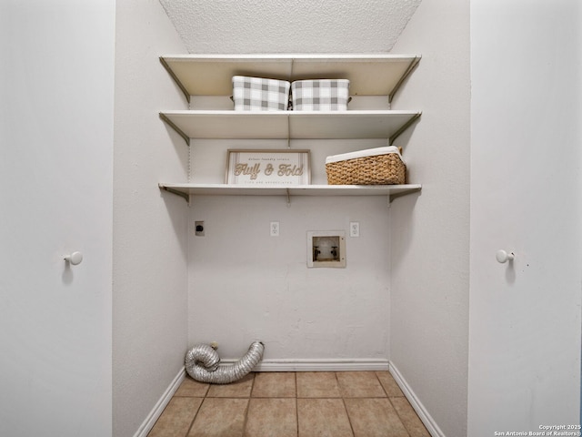 laundry room featuring hookup for a washing machine, light tile patterned floors, a textured ceiling, and hookup for an electric dryer