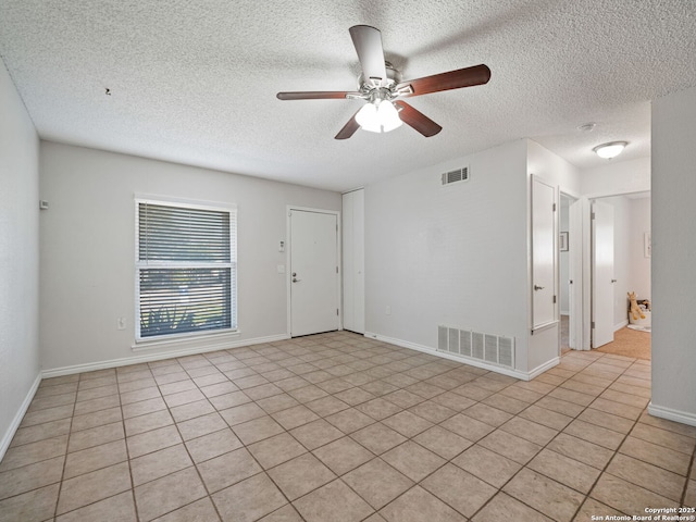 spare room with light tile patterned floors, a textured ceiling, and ceiling fan