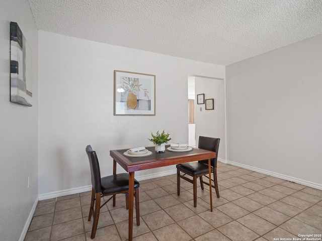 tiled dining space with a textured ceiling