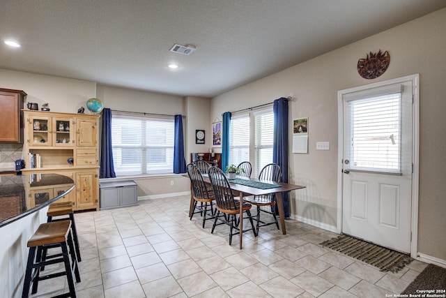 dining room with light tile patterned floors and a textured ceiling