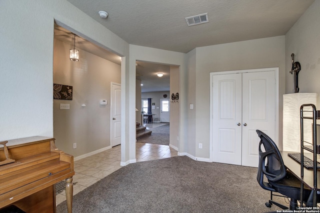 carpeted home office with a textured ceiling