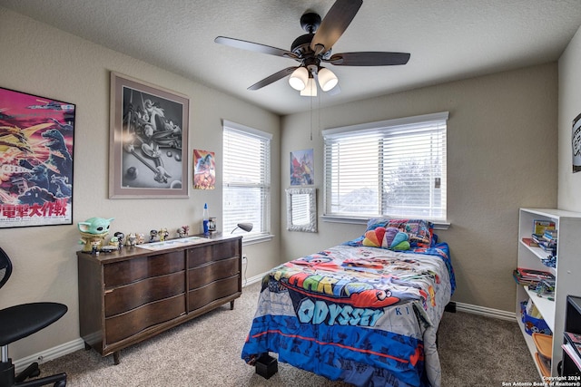 bedroom featuring ceiling fan, carpet floors, and a textured ceiling