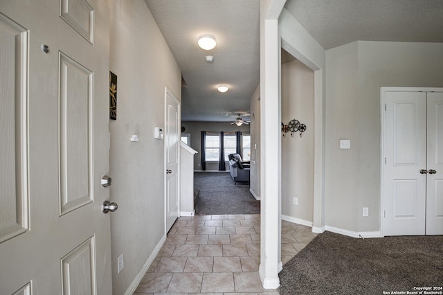 foyer entrance featuring ceiling fan and light colored carpet