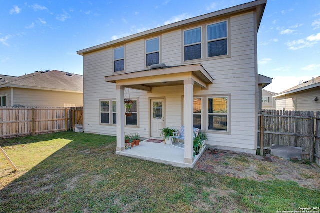 rear view of house with a yard and a patio