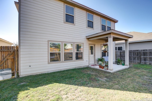 rear view of property featuring a yard and a patio