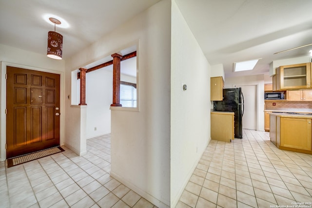 tiled foyer entrance featuring a skylight