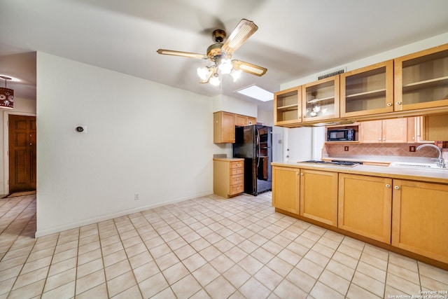 kitchen with decorative backsplash, ceiling fan, sink, black appliances, and light tile patterned floors