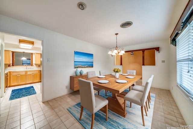 dining room featuring a notable chandelier, light tile patterned floors, and sink