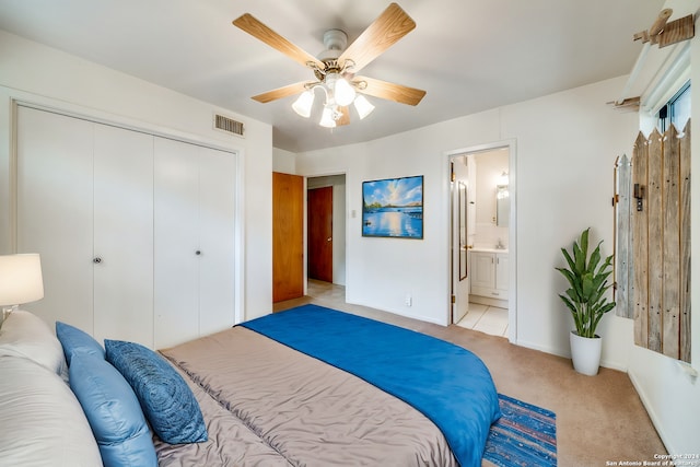 carpeted bedroom featuring ensuite bath, ceiling fan, and a closet