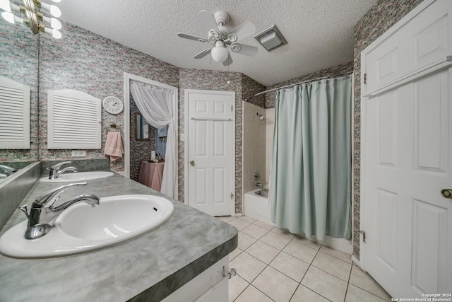 bathroom featuring vanity, a textured ceiling, ceiling fan with notable chandelier, shower / bath combo with shower curtain, and tile patterned flooring