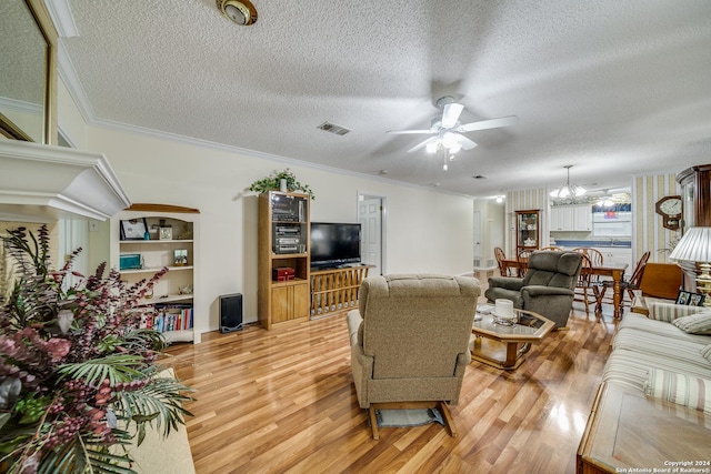 living room with a textured ceiling, light hardwood / wood-style flooring, ceiling fan with notable chandelier, and ornamental molding