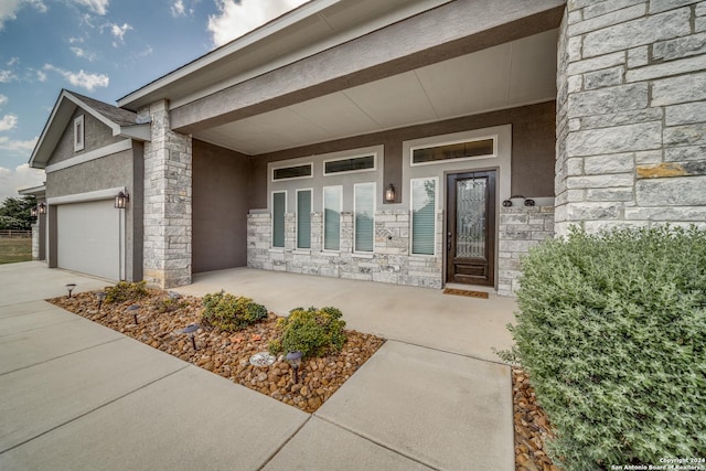 view of exterior entry featuring a porch and a garage