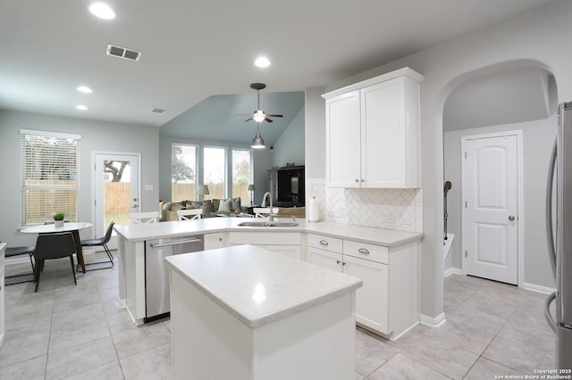 kitchen with sink, backsplash, kitchen peninsula, lofted ceiling, and appliances with stainless steel finishes