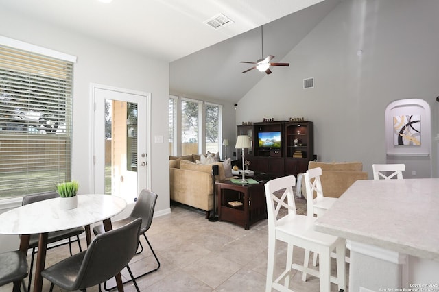 tiled dining area featuring high vaulted ceiling and ceiling fan