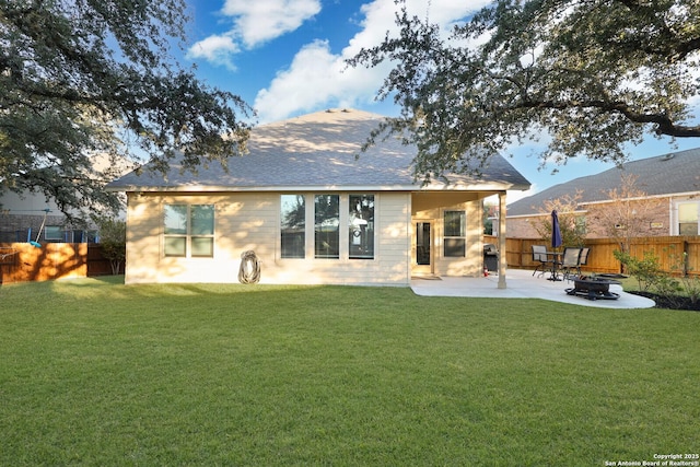 rear view of house with a mountain view, a yard, an outdoor fire pit, and a patio