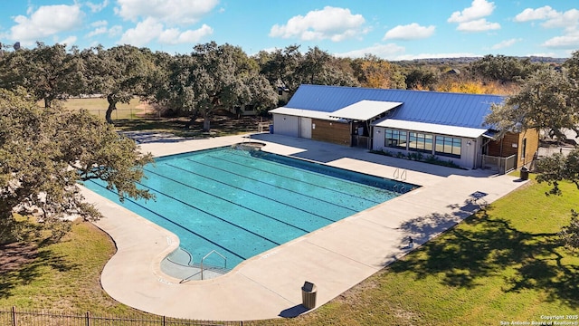 view of pool with a patio area and a yard