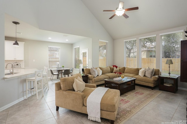 tiled living room with ceiling fan, sink, and high vaulted ceiling