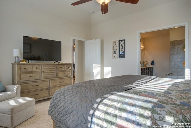 bedroom featuring light carpet, ensuite bathroom, and ceiling fan