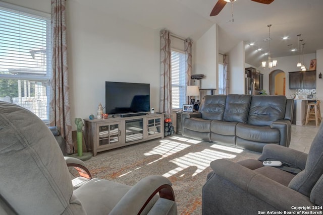 living room featuring ceiling fan, a healthy amount of sunlight, and lofted ceiling