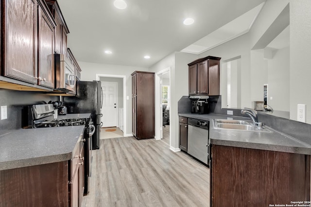 kitchen featuring sink, stainless steel appliances, dark brown cabinets, and light hardwood / wood-style flooring