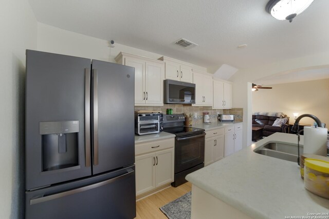 kitchen with white cabinetry, sink, ceiling fan, stainless steel appliances, and tasteful backsplash