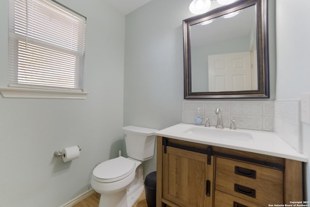 bathroom with vanity, backsplash, and toilet