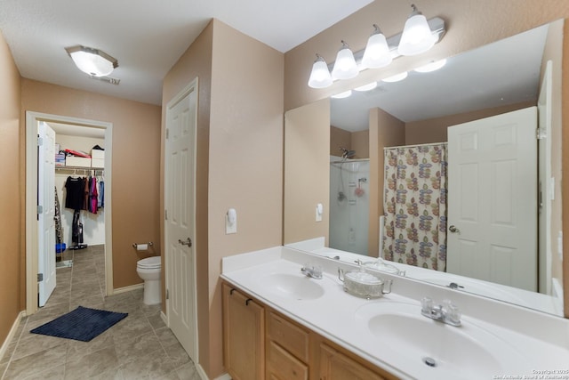 bathroom with walk in shower, vanity, and toilet