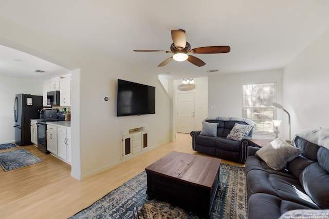 living room featuring light hardwood / wood-style floors and ceiling fan