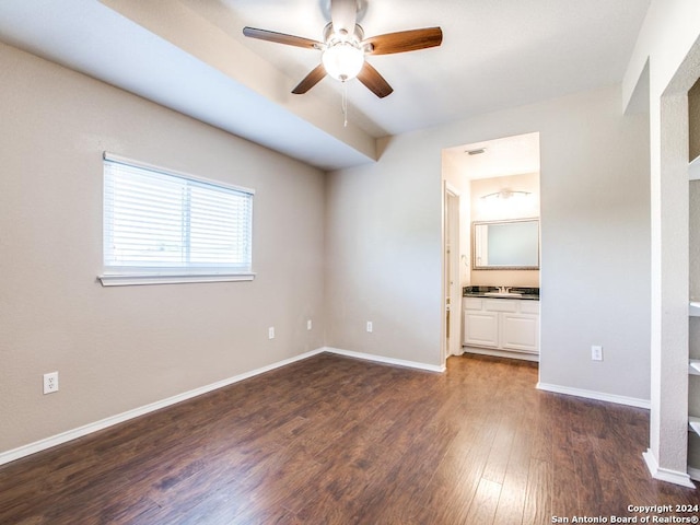 unfurnished bedroom featuring ceiling fan, dark hardwood / wood-style floors, and connected bathroom