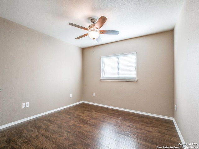 empty room featuring ceiling fan and dark hardwood / wood-style flooring