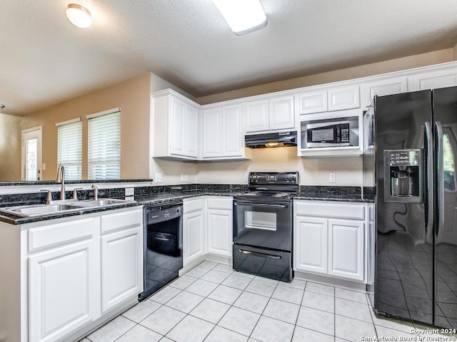 kitchen featuring dark stone counters, sink, black appliances, light tile patterned floors, and white cabinets