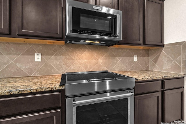 kitchen featuring appliances with stainless steel finishes, backsplash, light stone counters, and dark brown cabinetry