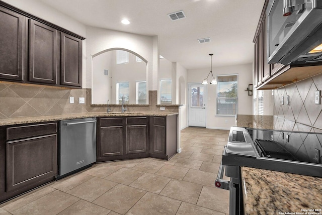 kitchen with dark brown cabinets, stainless steel appliances, sink, an inviting chandelier, and hanging light fixtures