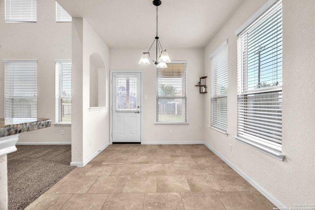 carpeted foyer entrance with a chandelier